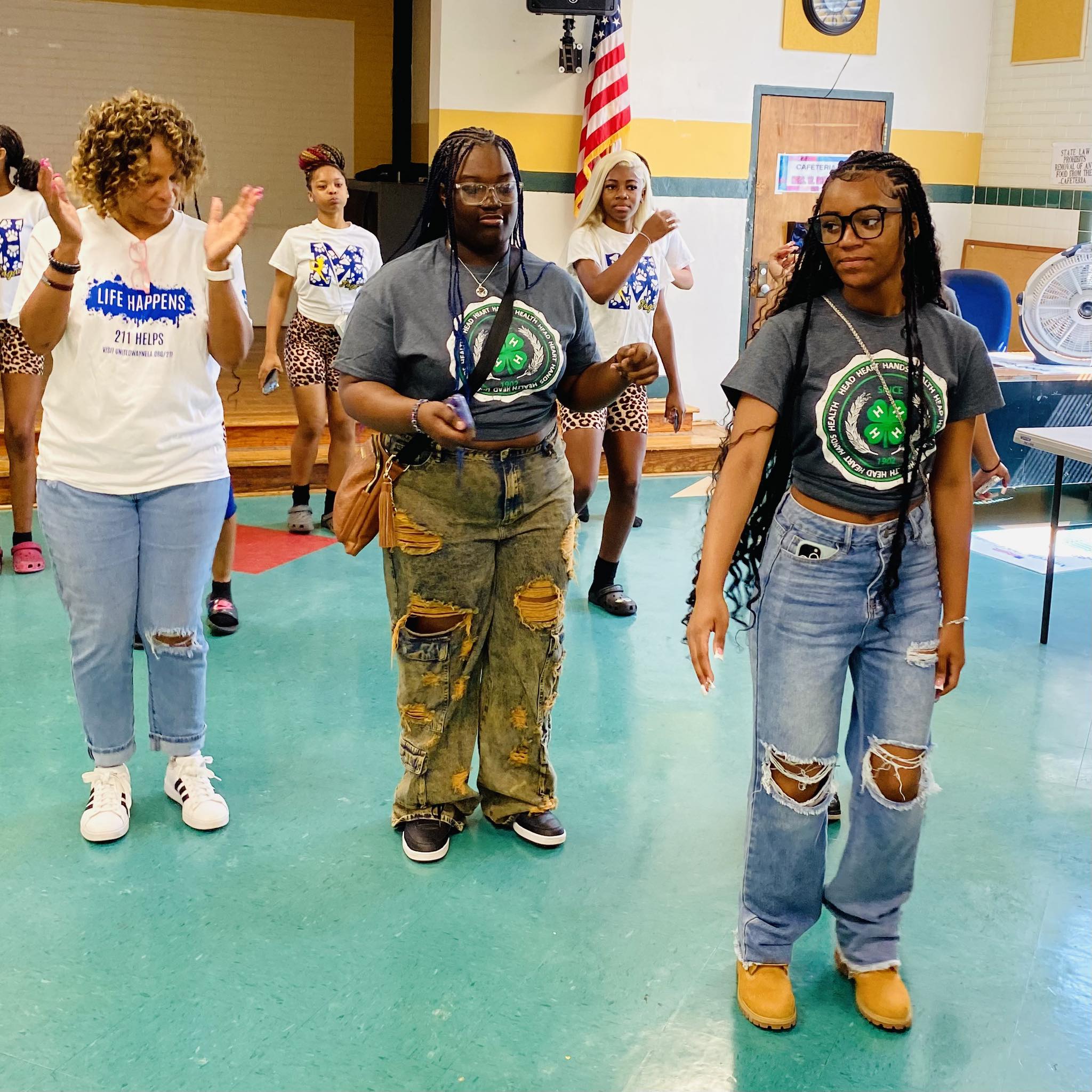 A woman and two girls line dancing.